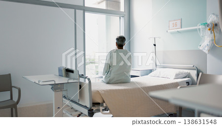 Back, healthcare and a woman on a hospital bed by the window in recovery or waiting for a visit. Medical, cancer and a patient thinking about the future of medicine in a health clinic for treatment Back, healthcare and a woman on a hospital bed by the window in recovery or waiting for a visit. Medical, cancer and a patient thinking about the future of medicine in a health clinic for treatment 138631548