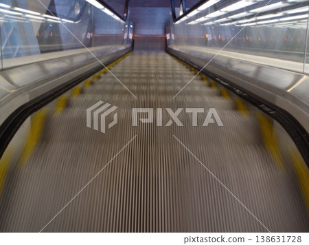 Top view, stairs and escalator in modern building for travel, moving and transport in airport. Metal, steel and closeup of electrical stairway in shopping mall, office or subway for urban commute Top view, stairs and escalator in modern building for travel, moving and transport in airport. Metal, steel and closeup of electrical stairway in shopping mall, office or subway for urban commute 138631728