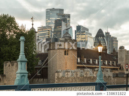 A captivating visual timeline of the city, the medieval battlements of the Tower of London are framed by the soaring skyscrapers of the City, illustrating a seamless blend of London storied past and A captivating visual timeline of the city, the medieval battlements of the Tower of London are framed by the soaring skyscrapers of the City, illustrating a seamless blend of London storied past and 138631822