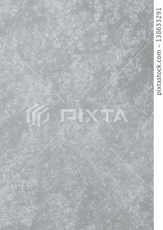 Snow Texture Close-Up. White Winter Snow Surface with Crystalline Pattern and Frost Details. Macro close-up view of natural snow texture showing detailed crystalline structure and frost patterns on wh 138633291