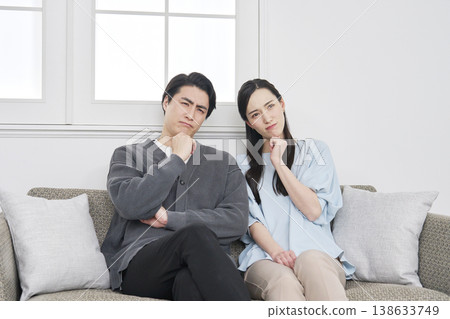 A middle-aged couple struggling with their living room A middle-aged couple struggling with their living room 138633749