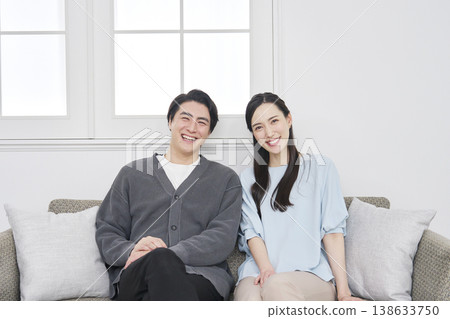 Portrait of a middle-aged couple in their living room, looking directly at the camera. Portrait of a middle-aged couple in their living room, looking directly at the camera. 138633750