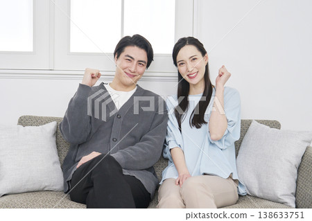 一對中年夫婦在客廳擺出勝利的姿勢。 138633751