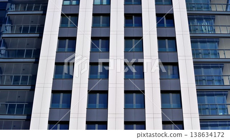 Exterior of a high modern multi-story apartment building - facade, windows and balconies. 138634172