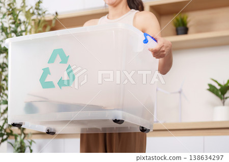 Woman holding recycling bin promoting eco-friendly practices 138634297