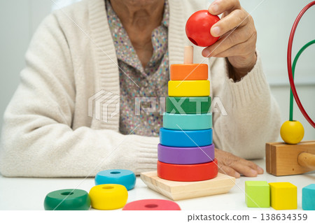 Asian elderly woman playing enhancing skill board game. Asian elderly woman playing enhancing skill board game. 138634359