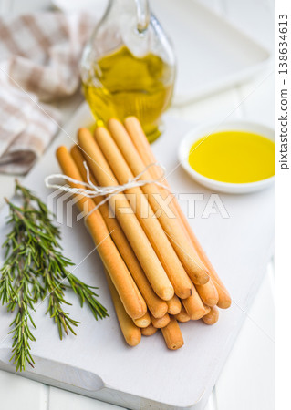 Bundle Of Crispy Breadsticks With Rosemary And Olive Oil Dip On White Wooden Table Bundle Of Crispy Breadsticks With Rosemary And Olive Oil Dip On White Wooden Table 138634613