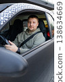 Adult man sitting behind steering wheel driving car and looking at camera, everyday transportation and lifestyle concept. 138634669