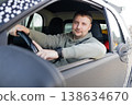 Adult man sitting behind steering wheel driving car and looking at camera, everyday transportation and lifestyle concept. 138634670