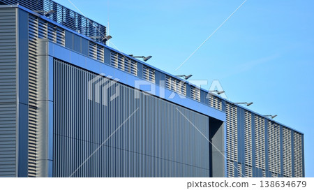 The futuristic building has engineered vertical cladding steel frame panels. The exterior wall of a contemporary commercial style building with aluminum metal composite panels. The futuristic building has engineered vertical cladding steel frame panels. The exterior wall of a contemporary commercial style building with aluminum metal composite panels. 138634679