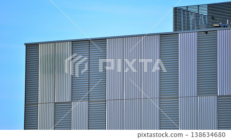 The futuristic building has engineered vertical cladding steel frame panels. The exterior wall of a contemporary commercial style building with aluminum metal composite panels.  138634680