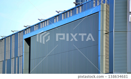 The futuristic building has engineered vertical cladding steel frame panels. The exterior wall of a contemporary commercial style building with aluminum metal composite panels. The futuristic building has engineered vertical cladding steel frame panels. The exterior wall of a contemporary commercial style building with aluminum metal composite panels. 138634681