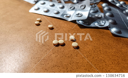 Loose Yellow Tablets with Used Blister Packs in Background Loose Yellow Tablets with Used Blister Packs in Background 138634716