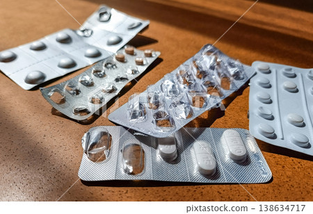 Five Used Blister Packs with Pills on Wooden Table, Angled View Five Used Blister Packs with Pills on Wooden Table, Angled View 138634717