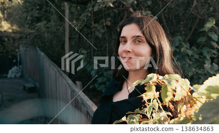 Young woman portrait with soft smile in natural outdoor light 138634863
