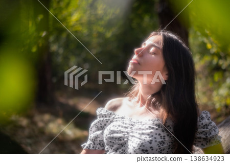 Relaxed young woman with closed eyes in forest light Relaxed young woman with closed eyes in forest light 138634923