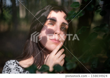 Artistic portrait of young woman framed by leaves Artistic portrait of young woman framed by leaves 138634924