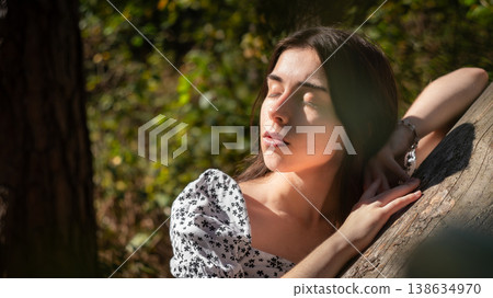 Peaceful young woman with closed eyes in woodland 138634970