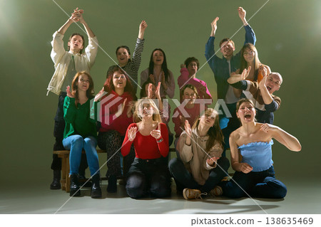 Diverse group expressing strong emotions cheering and celebrating in studio environment 138635469