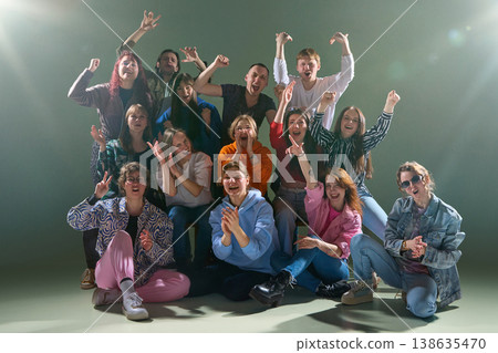 Group of young people cheering loudly and reacting together with high energy in studio. Group of young people cheering loudly and reacting together with high energy in studio. 138635470