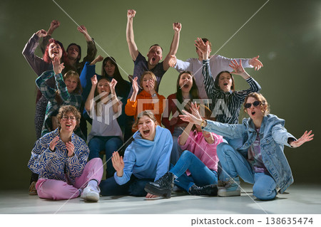 Excited diverse group expressing strong emotions and cheering in studio environment. Excited diverse group expressing strong emotions and cheering in studio environment. 138635474