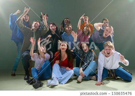 Group of young people cheering and reacting together in studio with vibrant energy Group of young people cheering and reacting together in studio with vibrant energy 138635476