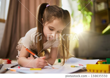 Close up of girl drawing with pencil showing concentration and creativity. Close up of girl drawing with pencil showing concentration and creativity. 138635550