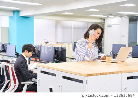 男女商務人士在免費辦公地址的辦公室裡各自處理自己的工作。 男女商務人士在免費辦公地址的辦公室裡各自處理自己的工作。 138635694