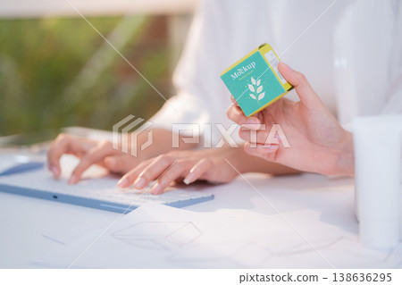 Hand holding cosmetic packaging mockup box, graphic designer and development branding project. 138636295