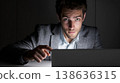 Young businessman focused on laptop screen in a dark room showcasing digital engagement and modern technology in a corporate environment. Generative AI 138636315