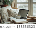 Cozy indoor workspace with a laptop and a cup of coffee surrounded by books and plush cushions perfect for creative productivity at home. Generative AI 138636323