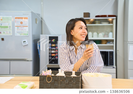 A businesswoman takes a coffee break in the break area between working on her laptop. 138636506