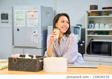 一位女商人利用工作間隙,在休息區喝杯咖啡。 一位女商人利用工作間隙,在休息區喝杯咖啡。 138636510