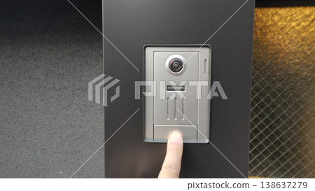 Finger pressing the intercom 138637279