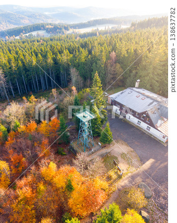 Slovanka Lookout Tower stands tall amidst vibrant autumn colors in the Jizera Mountains. Visitors enjoy panoramic views, surrounded by golden and red foliage under the clear sky. Slovanka Lookout Tower stands tall amidst vibrant autumn colors in the Jizera Mountains. Visitors enjoy panoramic views, surrounded by golden and red foliage under the clear sky. 138637782