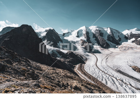 The striking landscape showcases Piz Palu towering over the Pers Glacier, with rocky ridges beneath a clear blue sky. This breathtaking scene exemplifies the beauty of the Swiss Alps. The striking landscape showcases Piz Palu towering over the Pers Glacier, with rocky ridges beneath a clear blue sky. This breathtaking scene exemplifies the beauty of the Swiss Alps. 138637895