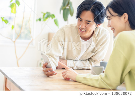 A couple looking at a smartphone A couple looking at a smartphone 138638072