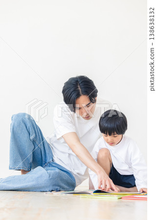 A father reading a picture book to his child A father reading a picture book to his child 138638132