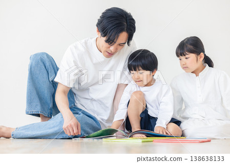 一位父親正在唸圖畫書給孩子聽。 138638133