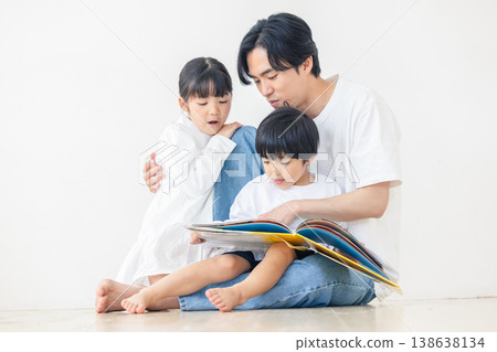 一位父親正在唸圖畫書給孩子聽。 138638134