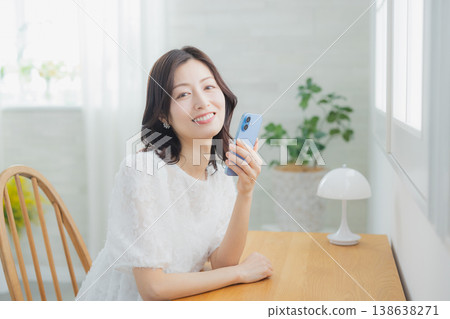 A woman watching a smartphone A woman watching a smartphone 138638271