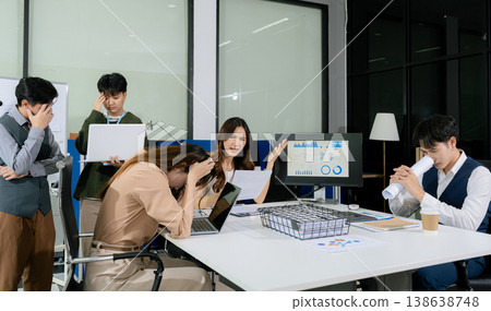 business people, teamwork, people and crisis concept - business team sitting sad and solving problems in the office. business people, teamwork, people and crisis concept - business team sitting sad and solving problems in the office. 138638748