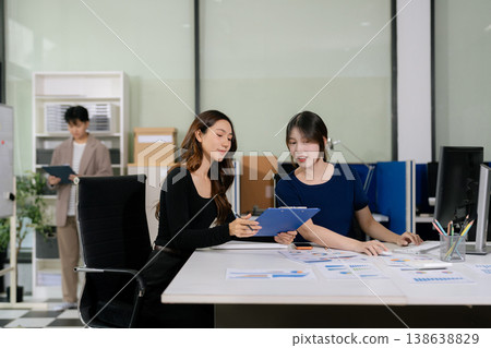 Business team working on a project in the office or reviewing and discussing a business project. 138638829