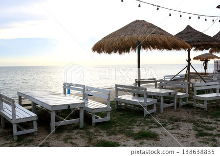 Chairs and tables row on beach with sunset. 138638835