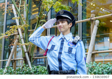 A young Japanese male security guard salutes. Photo courtesy of Denpa Gakuen Educational Foundation, Tokyo Electronics College. A young Japanese male security guard salutes. Photo courtesy of Denpa Gakuen Educational Foundation, Tokyo Electronics College. 138638907
