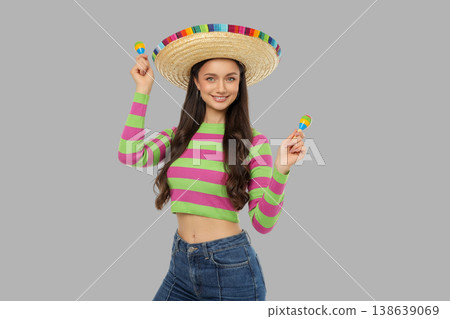 Cinco de Mayo, Woman in sombrero holds maracas, colorful shirt Cinco de Mayo, Woman in sombrero holds maracas, colorful shirt 138639069