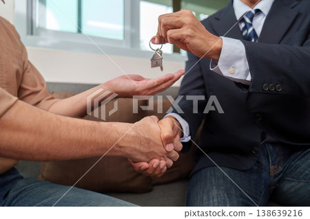 Real estate agent handing over keys after deal Real estate agent handing over keys after deal 138639216