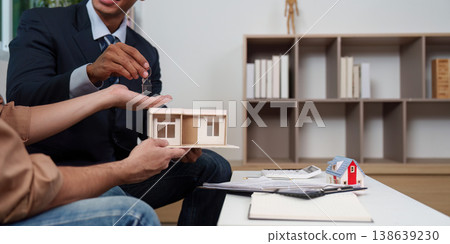 Real estate agent presenting property model to client Real estate agent presenting property model to client 138639230