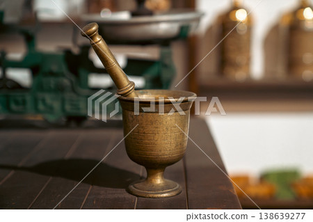 Antique Brass Mortar and Pestle on Wooden Table in Kitchen Setting Antique Brass Mortar and Pestle on Wooden Table in Kitchen Setting 138639277