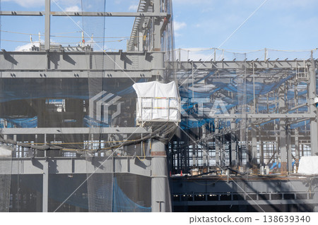 A construction site with temporary scaffolding during steel frame erection work. 138639340